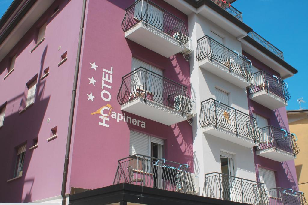 a pink building with balconies on the side of it at Hotel Capinera in Caorle
