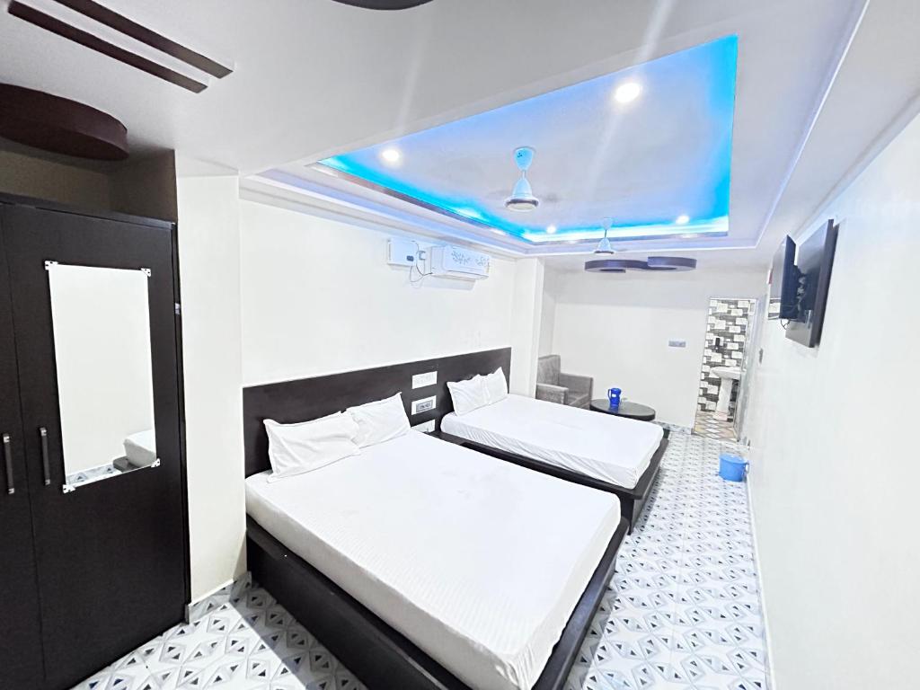 加雅SS Hotel的一间卧室，里面有两张床和一台电视