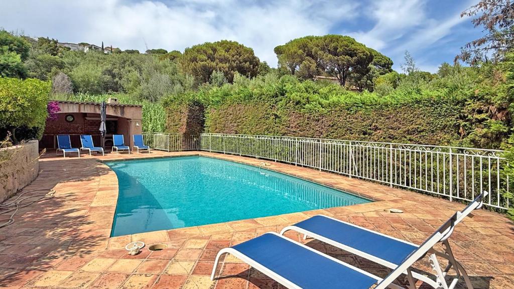 une piscine avec deux chaises et une clôture dans l'établissement Villa Cavok, à Sainte-Maxime