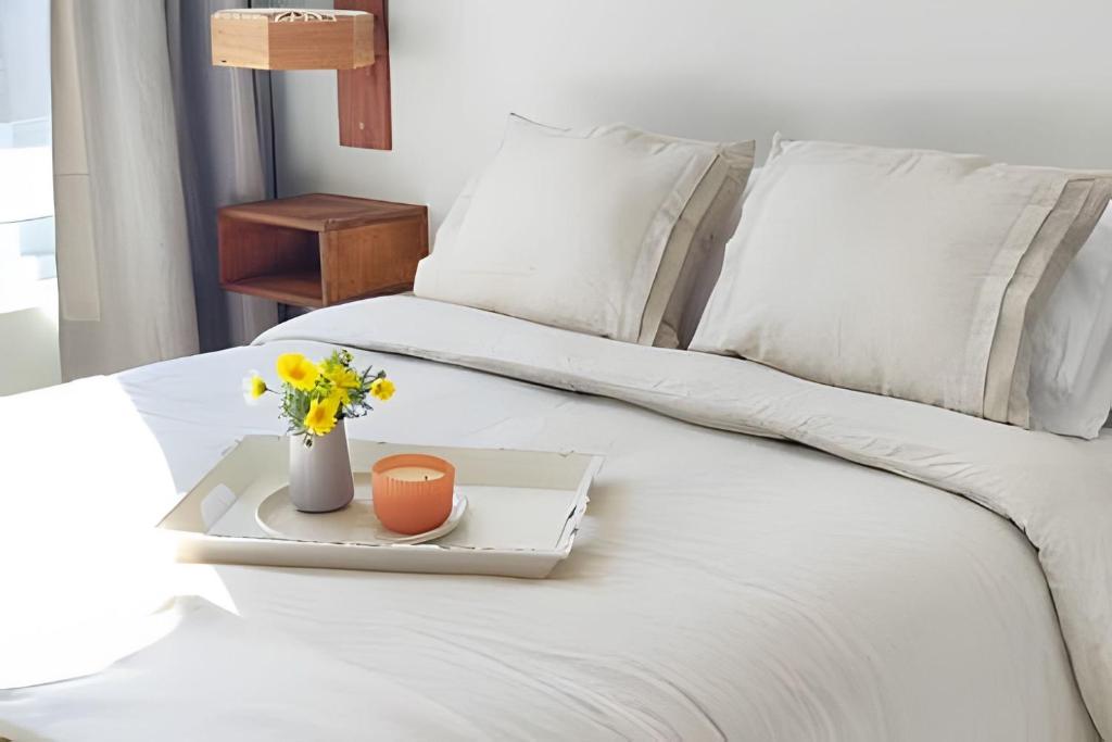 a white bed with a tray with flowers on it at 505 ,Depto studio NUEVO!, Boutique in Viña del Mar