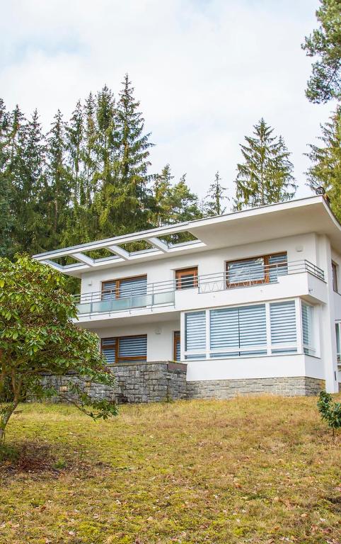 Casa blanca grande con ventanas en un campo en Vilas & Wellness Resort Orlík, en KozÃ¡rovice