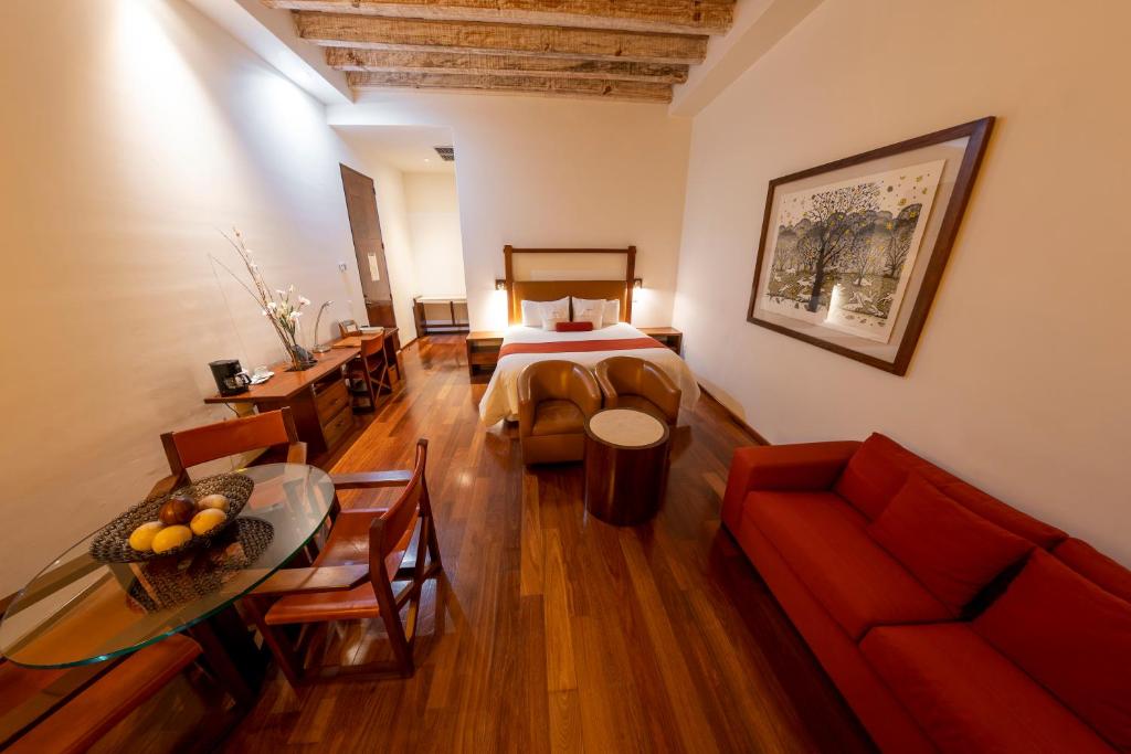 a room with a bed and a table and a couch at Hotel Boutique Casa San Diego in Morelia