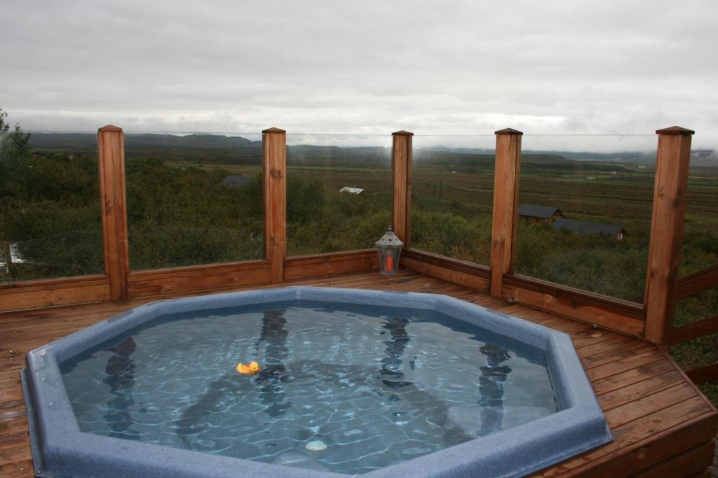 bañera de hidromasaje en una terraza con vistas en Sólbakki Holiday Home, en Egilsstadir