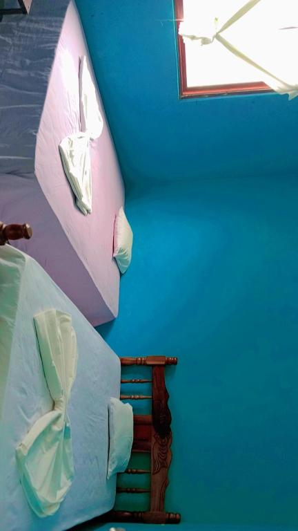 Voodi või voodid majutusasutuse Hostal Isla Natal toas