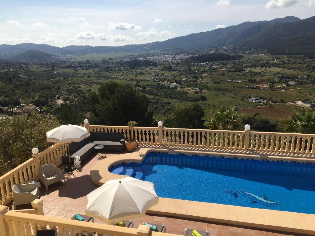 ハロンにあるVilla Almazaraのパラソルと山の景色が見えるプール