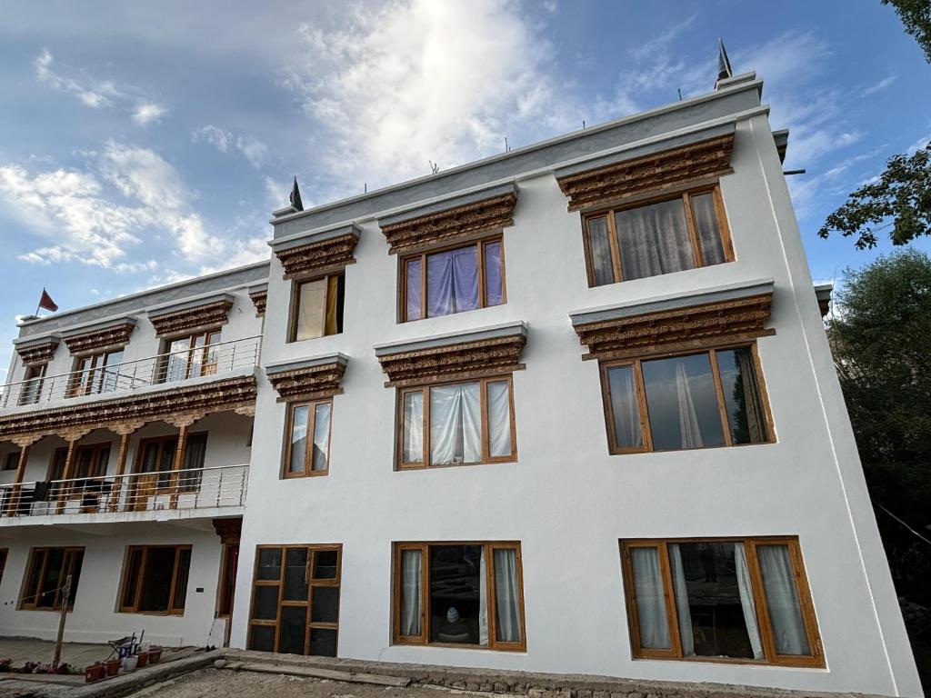 a white building with many windows on it at Skyline Homestay in Leh