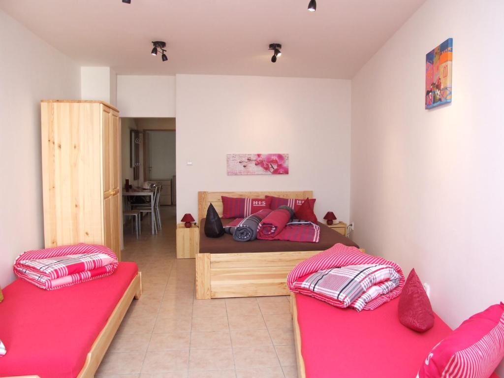 2 Betten in einem Zimmer mit rosa Kissen in der Unterkunft Apartment Ortler in Banská Štiavnica