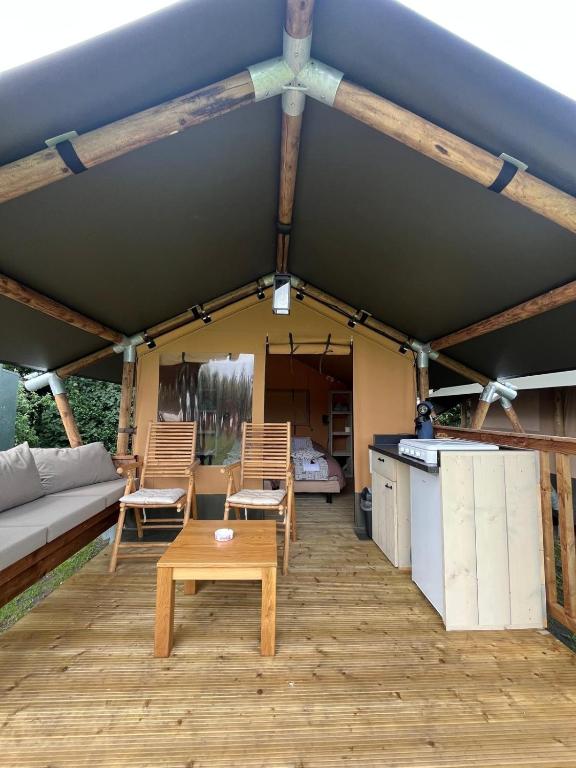 a patio with a table and chairs and a couch at Romala's Mini Glamp in Kiel