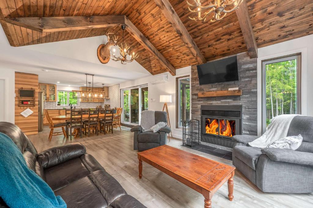 een woonkamer met een bank en een open haard bij Natur Rustik - En pleine nature avec Spa in Petite-Rivière-Saint-François