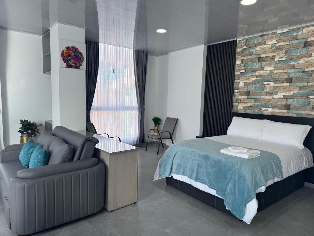 a bedroom with a bed and a chair at Sky Suite in Sogamoso