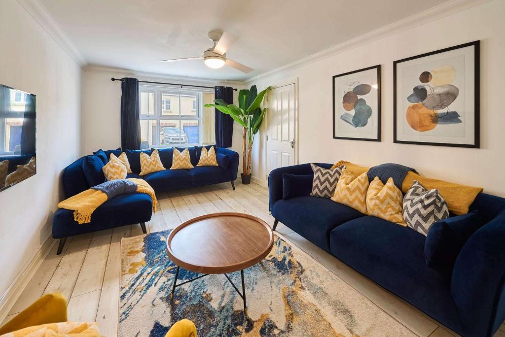 a living room with blue couches and a table at Host & Stay - Blueberry House in Launceston