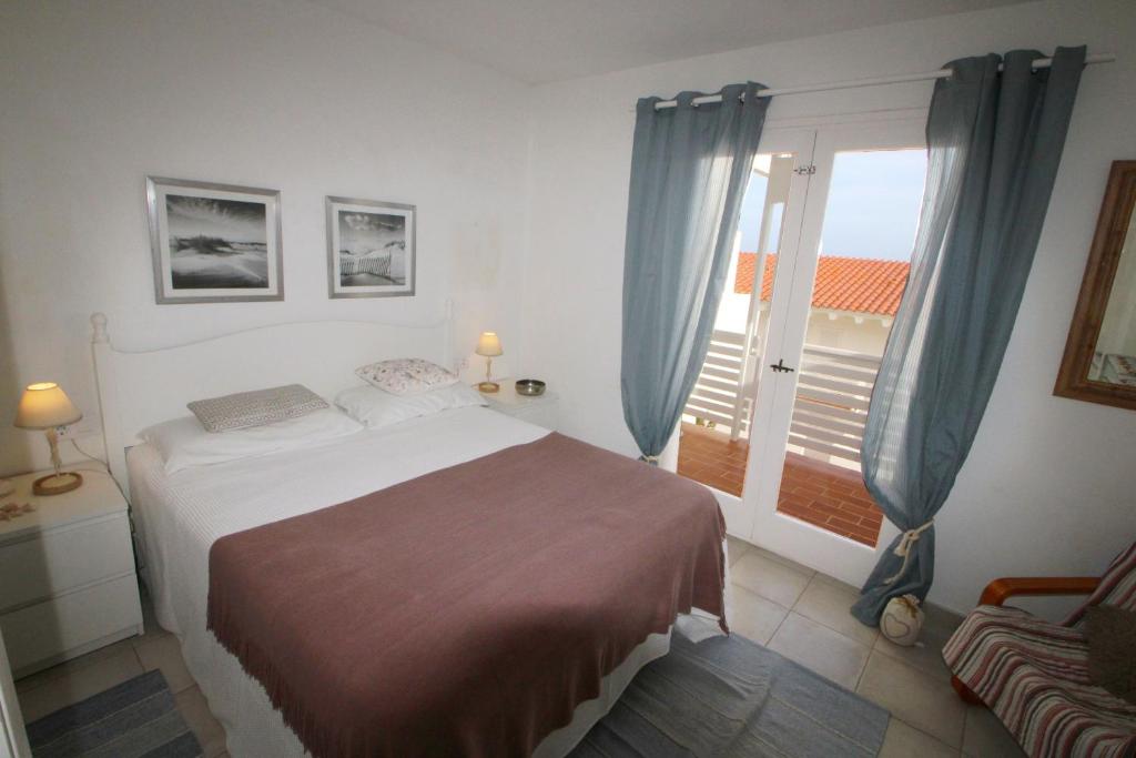 een slaapkamer met een bed en een raam met een balkon bij Casa Sol in Son Parc