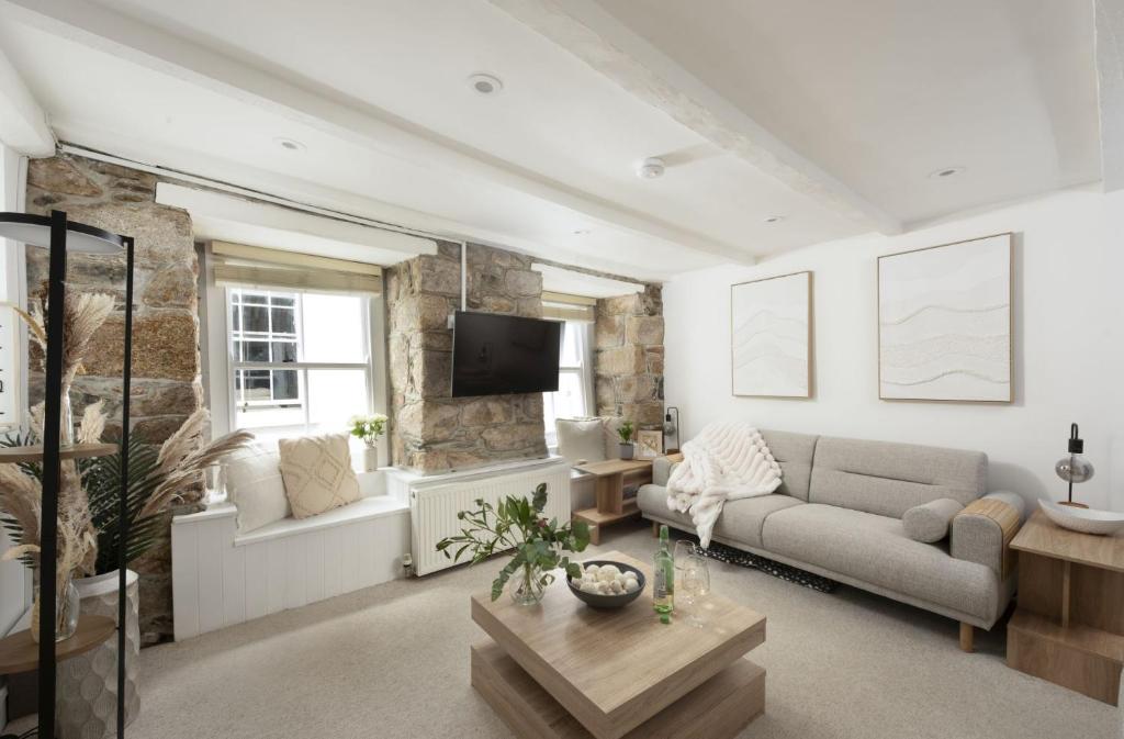 a living room with a couch and a tv at Fond Memories Cottage, The Digey, St Ives in St Ives