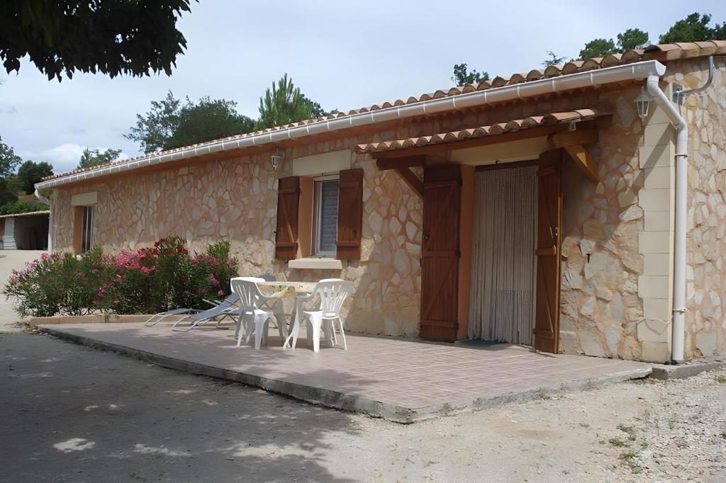 a patio with a table and chairs in front of a house at Les Romarins in Bédoin