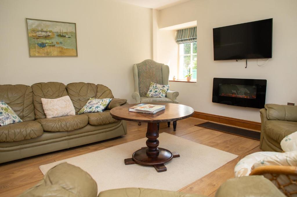 a living room with a couch and a table at Bayvil Newport, Pembrokeshire in Nevern