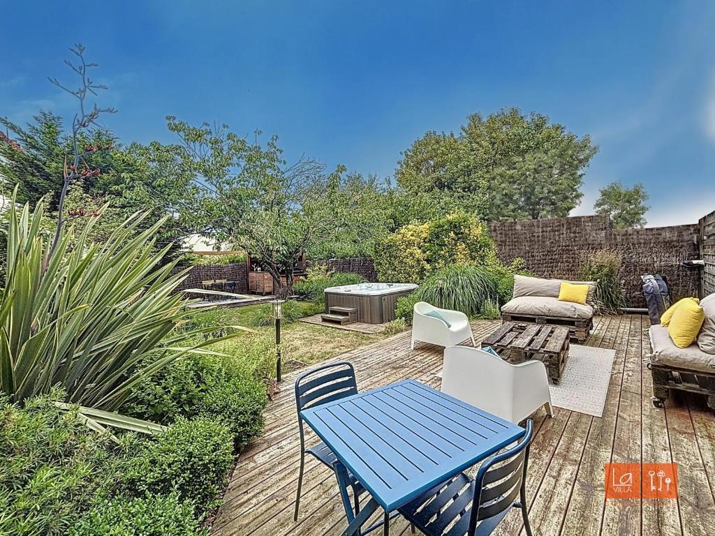 a patio with a table and chairs and a grill at L'ensoleillée - Proximité plage in Wimereux