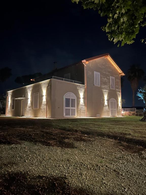 a house with lights on the side of it at night at Peacock apartments Latina in Latina