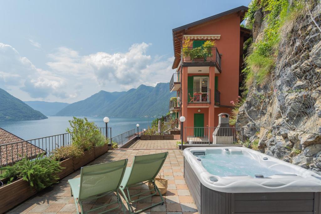 a hot tub on the side of a building next to the water at Blue Bliss Apartment by Rent All Como in Colonno