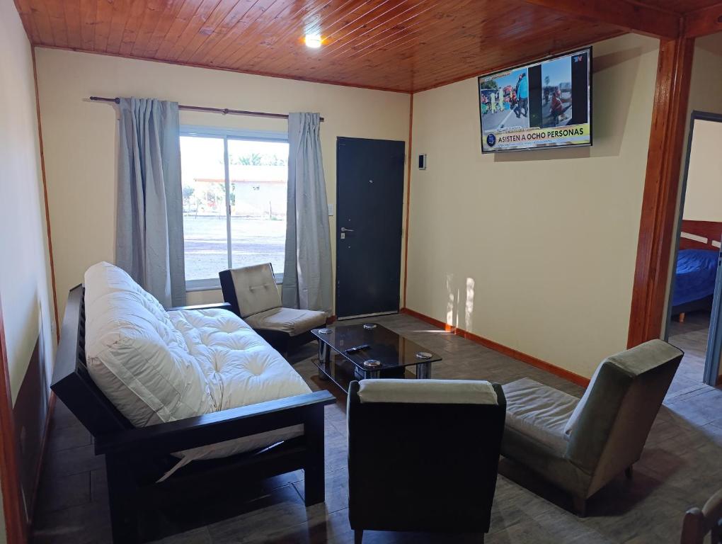 a living room with a couch and a chair at Cabañas Hamdan villa residencial laguna brava in Balcarce
