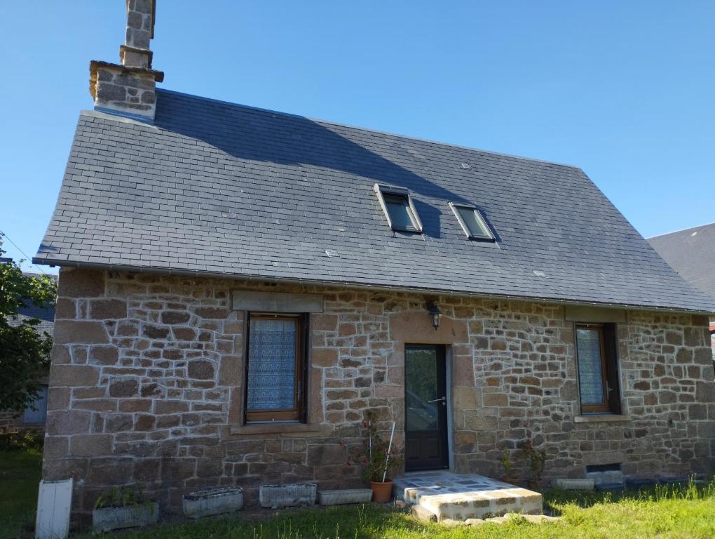 une ancienne maison en briques avec deux fenêtres. dans l'établissement Gîte accessible à la campagne, à Orliac-de-Bar