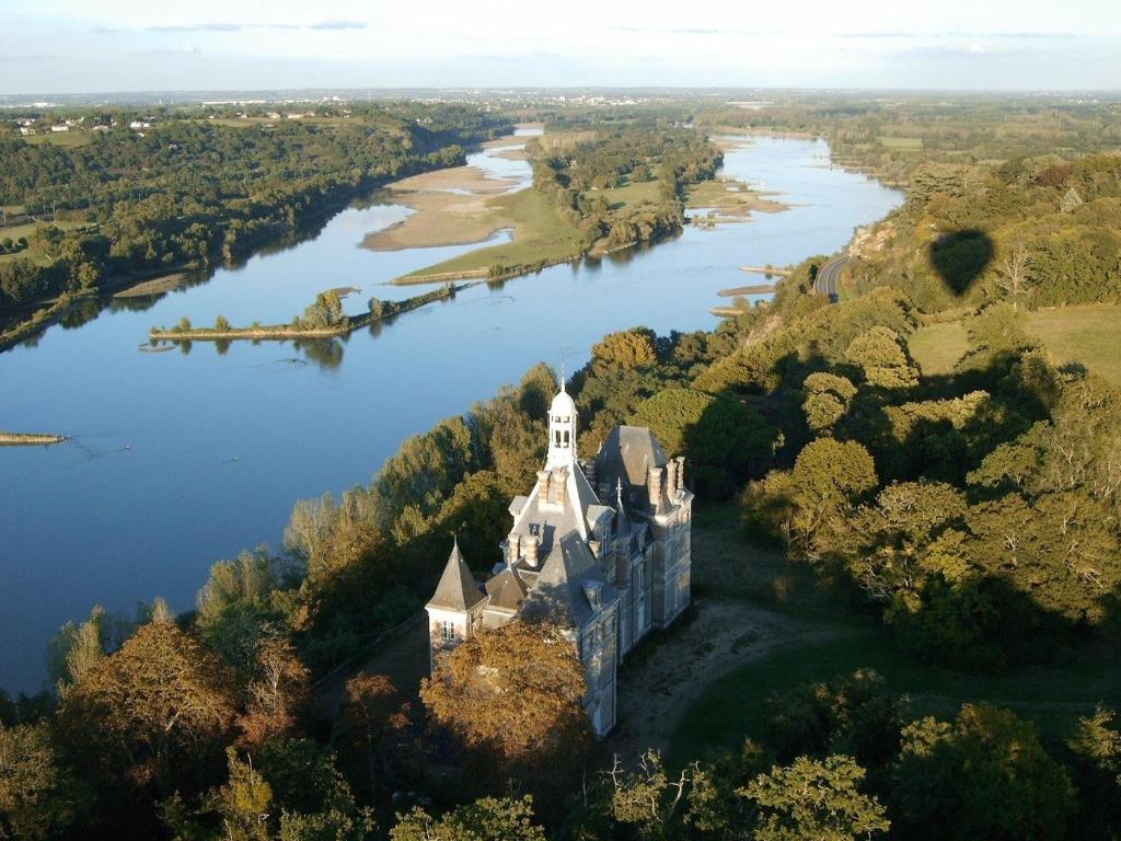 an aerial view of a castle in the middle of a river at château de La Colinière - vue sur parc in Champtoceaux