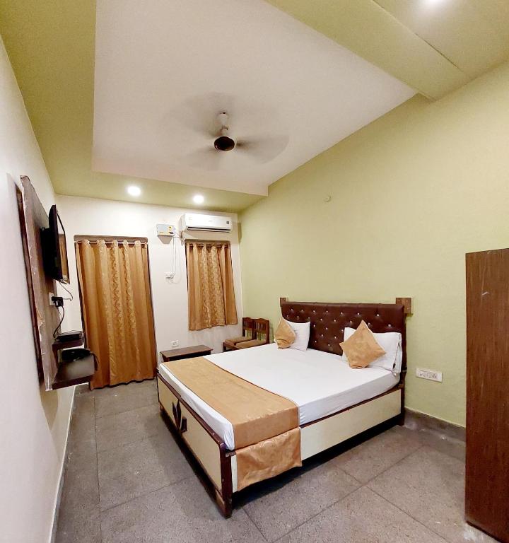 a bedroom with a bed and a television in it at Hotel Gokul Grand in Varanasi
