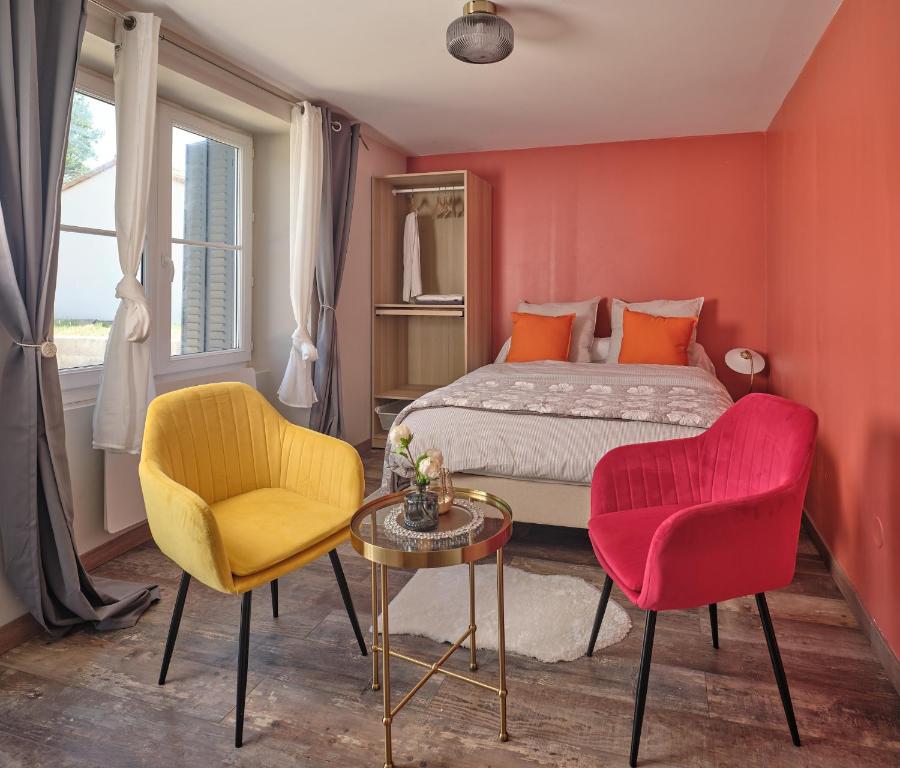 Un dormitorio con una cama y dos sillas y una mesa. en La Résidence AKWABA, en Saint-Philbert-de-Grand-Lieu