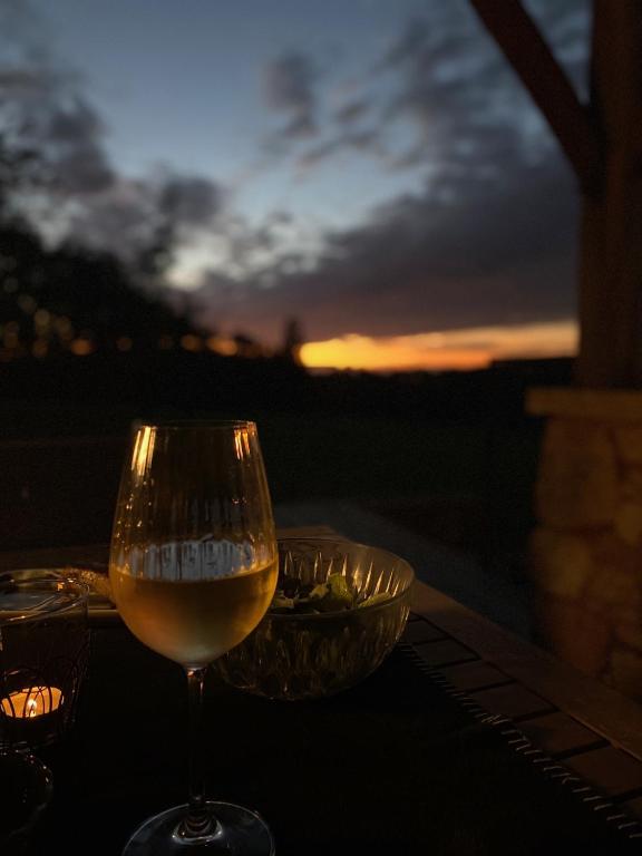- un verre de vin assis sur une table au coucher du soleil dans l'établissement Domaine de Cazal - Gîte 4 pers avec piscine au cœur de 26 hectares de nature préservée, à Saint-Cyprien