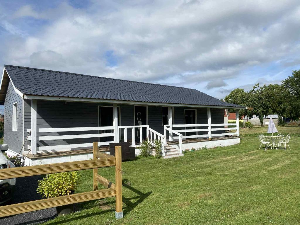 a small house with a fence in front of it at Maison en bois Baie de Somme in Saint-Blimont