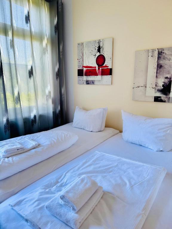 two beds in a room with white sheets and pillows at Siegener Balkon-Refugium in Plauen