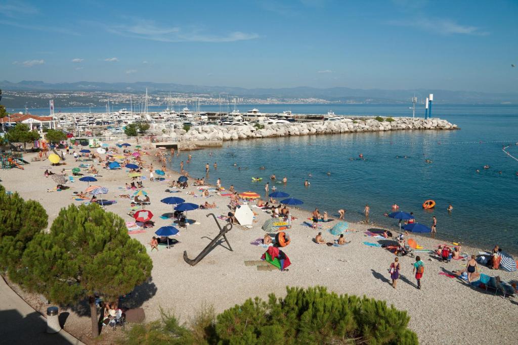 a group of people on a beach in the water at Apartment Sea Garden in Ičići