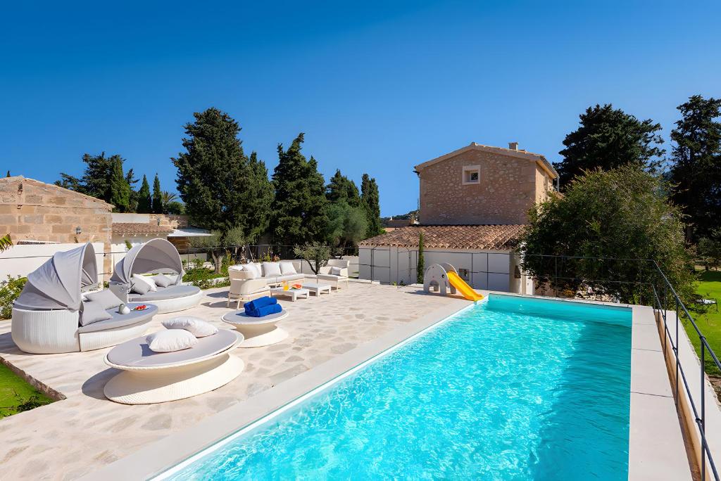 een zwembad met ligstoelen en een zwembad bij Can Mas Villa Antigua in Pollença