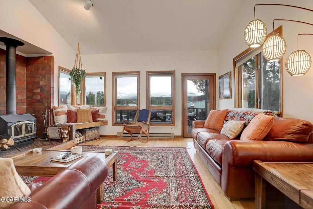 sala de estar con sofá de cuero y chimenea en 524 Sun River #8, en Fraser