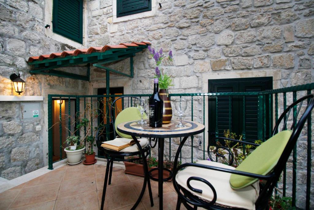 uma mesa com uma garrafa de vinho na varanda em Apartments Caralipeo em Makarska