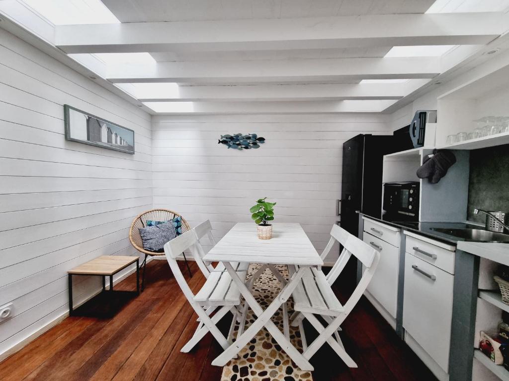 une petite cuisine avec une table et des chaises blanches dans l'établissement Studio 34, à Bourcefranc