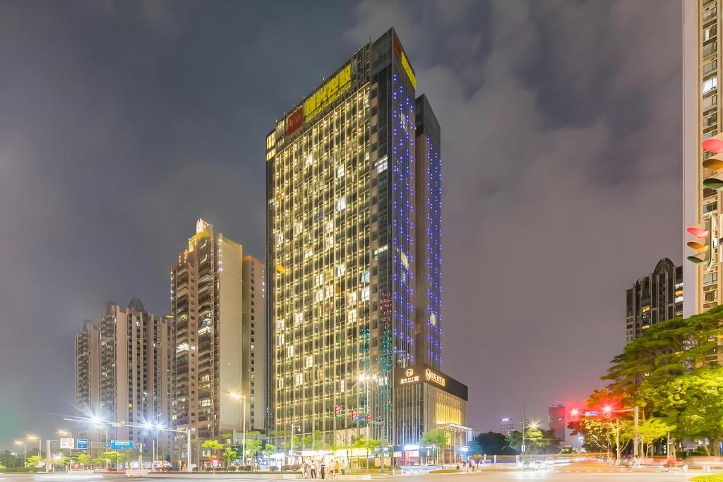 卓美雅酒店公寓（广州珠江新城店） في قوانغتشو: مبنى شاهق في مدينة في الليل