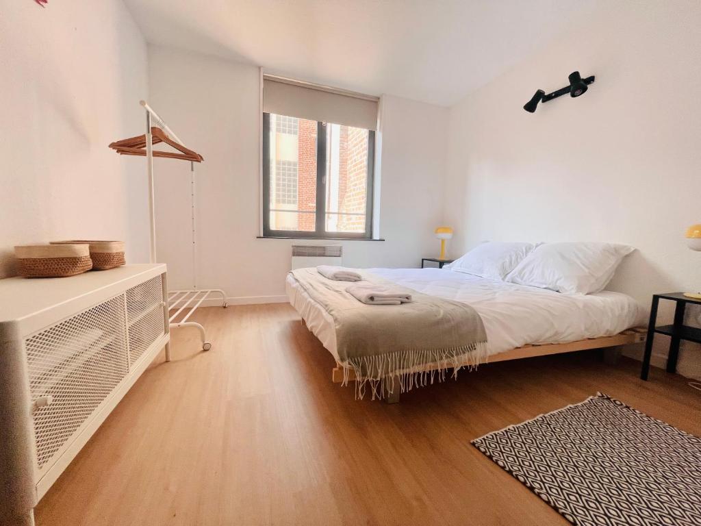 a white bedroom with a bed and a window at Ch'ti Lillois - Appartement 3 personnes Lille in Lille