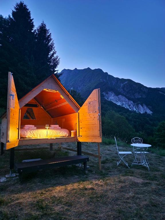 a bed in a tent with a table in a field at StarsBOX - La Vrata Gialla in Montemaggiore