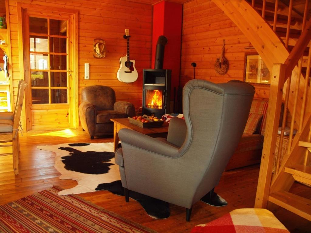 a living room with a chair and a fireplace at Wild West Lodge 48 Western-Feeling im Harz in Hasselfelde