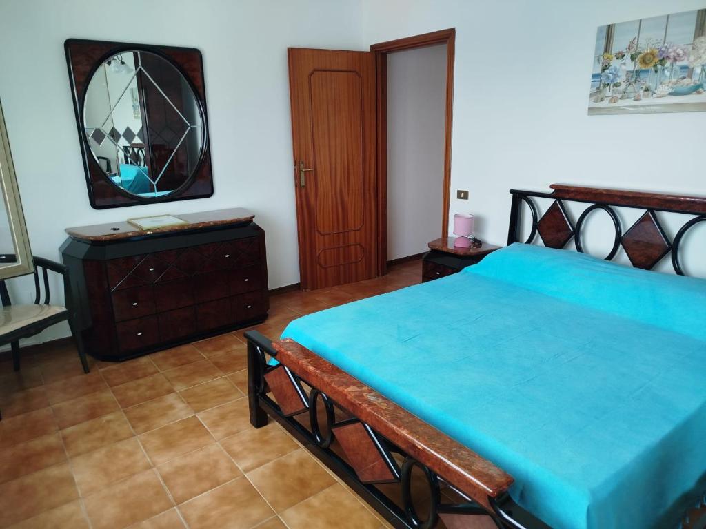 een slaapkamer met een blauw bed en een spiegel bij STELLA MARINA a 10 minuti dal mare in Formia