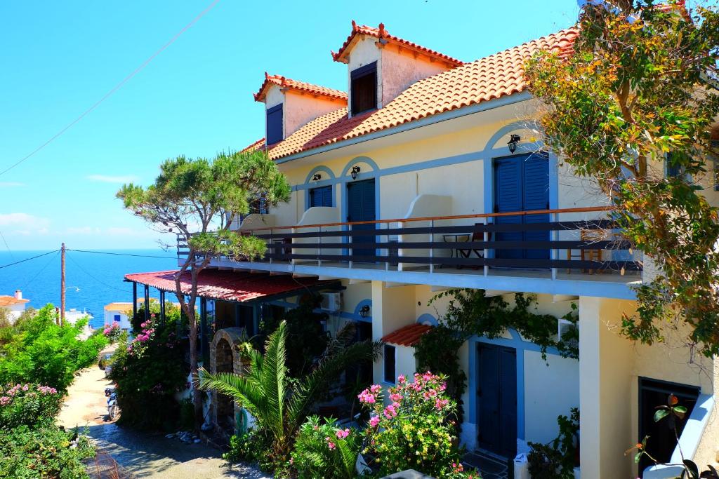 a house with blue doors and a balcony at Pension Galini in Armenistis