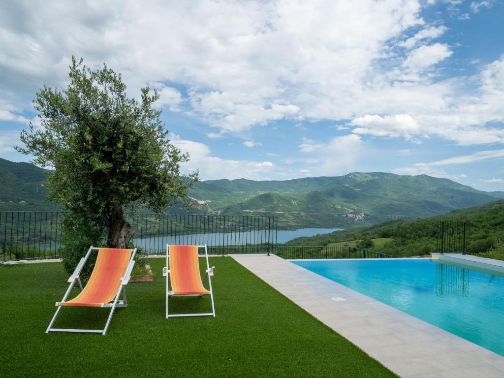two chairs and a tree next to a swimming pool at Apartment Bomba vista lago 7 by Interhome in Villa Santa Maria