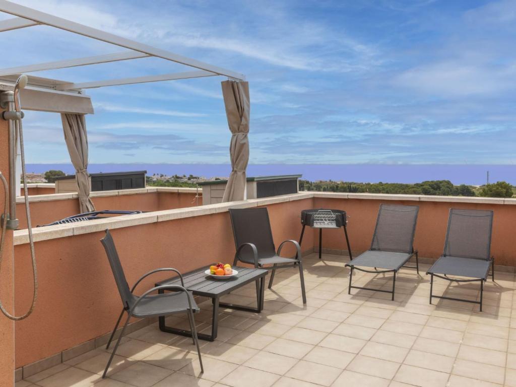 a patio with chairs and a table on a roof at Apartment Ronda Creixell by Interhome in Creixell
