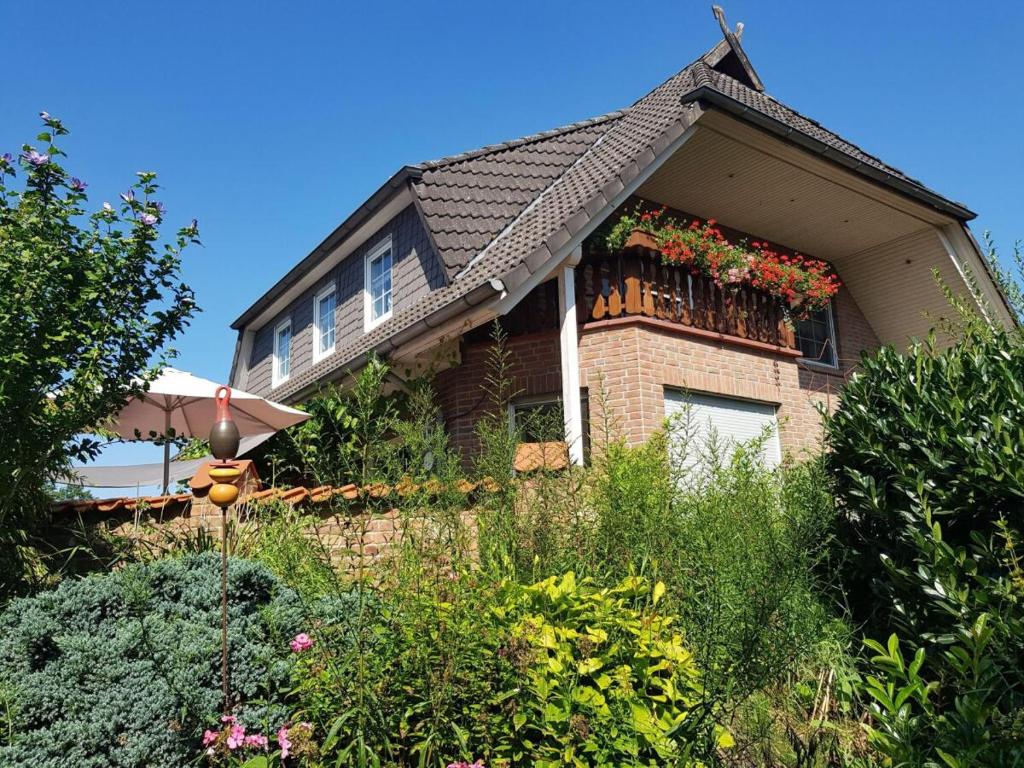 a house with a balcony with flowers on it at Ferienwohnung am Heidesee in Faßberg