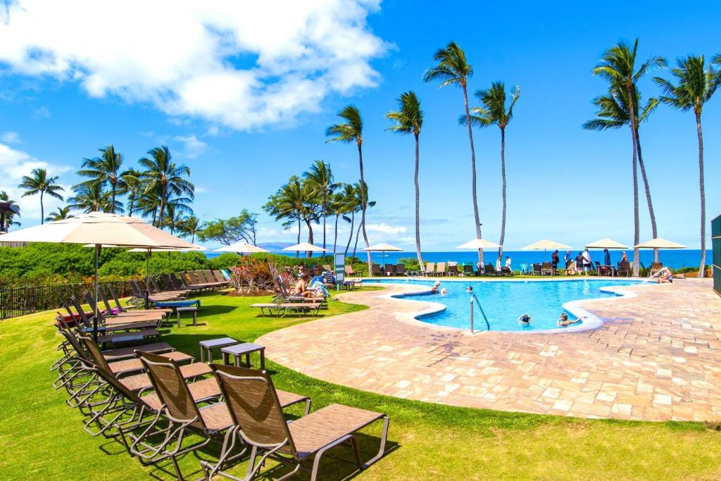 una piscina in un resort con sedie e palme di NEW KBM Resorts Ocean Views FREE CAR Wailea Ekahi 1-Bedroom Condo with Luxury Amenities WKV-45C a Wailea