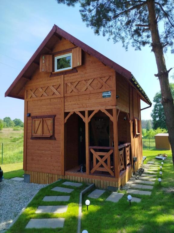 a large wooden cabin with a gambrel roof at Jeziorna Ostoja in Jodlow