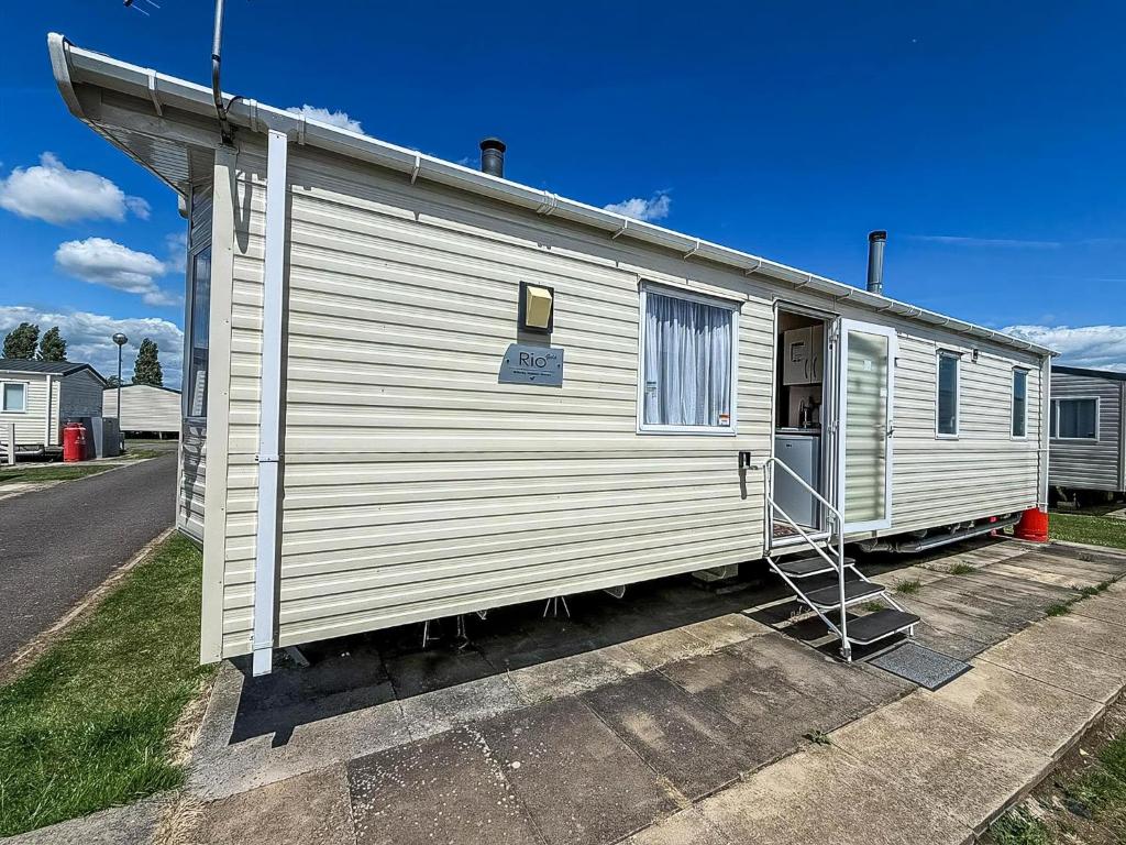 a white house with a ladder on the side of it at Fantastic 6 Berth Caravan At Haven Skegness Holiday Park Ref 88028Hr in Skegness