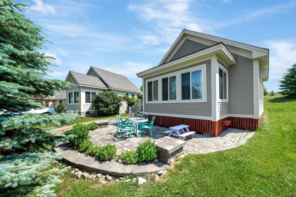 een huis met een terras met een tafel en stoelen bij The Sumac - 8 Natures in Cherry Valley