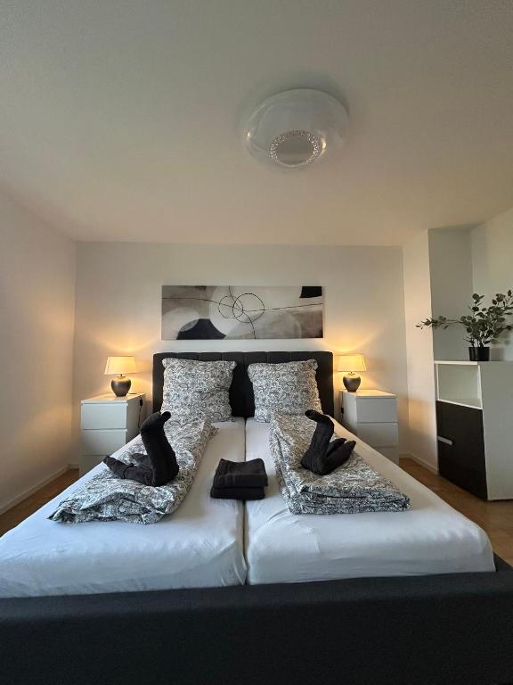 une chambre avec un grand lit blanc avec des oreillers noirs dans l'établissement Stielvolle Etagenwohnung in bester Lage, à Rodenbach