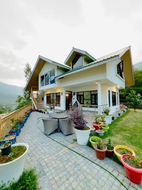 a house with potted plants in front of it at ROYALE PEAKS villa sonamarg Rd in Harganyiwan